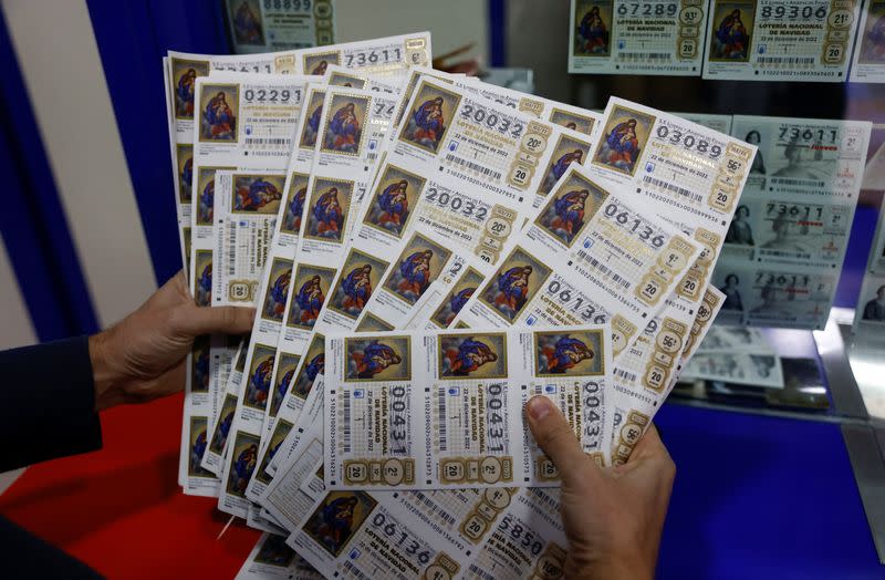 Un vendedor de lotería muestra décimos de lotería de Navidad en una tienda de lotería en la víspera del sorteo de la lotería de Navidad de España "El Gordo", en Ronda, España