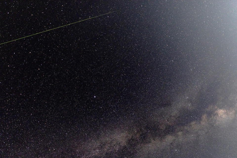 Starry night sky with a lone white streak.