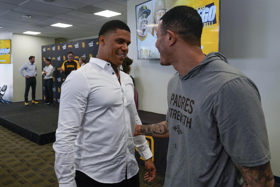 San Diego Padres outfielder Juan Soto, left, greets third baseman Manny Machado during a news conference at Petco Park Wednesday, Aug. 3, 2022, in San Diego. Soto, the generational superstar whose trade-deadline acquisition instantly made the Padres a strong playoff contender, was introduced at a news conference Wednesday along with fellow newcomer Josh Bell. (AP Photo/Gregory Bull)