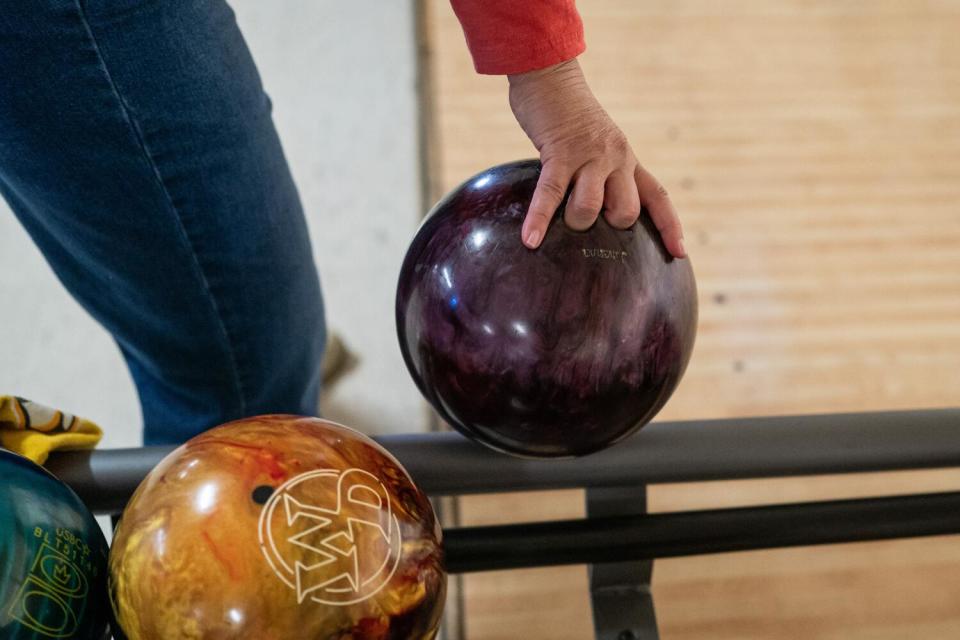 A bowler picks up a ball at Napa Bowl bowling alley on Friday, Oct. 27, 2023