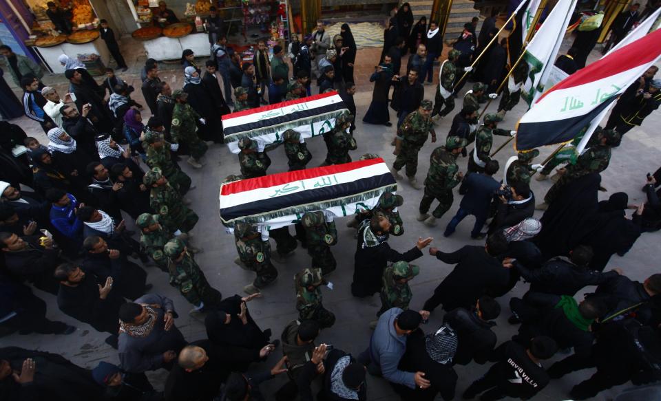 Members of Shi'ite group Asaib Ahl al-Haq, who support Syrian President Bashar al-Assad, carry the coffins of fighters from their group, during a funeral in Najaf, December 13, 2013. The Iraqi men, members of Asaib Ahl al-Haq, were killed in clashes with the Free Syrian Army in Syria, according to the group. (REUTERS/Alaa Al-Marjani)