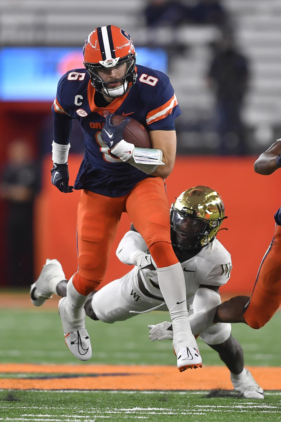 Syracuse quarterback Garrett Shrader (6) breaks a tackle by Wake Forest defensive back Malik Mustapha, bottom, during the second half of an NCAA college football game in Syracuse, N.Y., Saturday, Nov. 25, 2023. (AP Photo/Adrian Kraus)