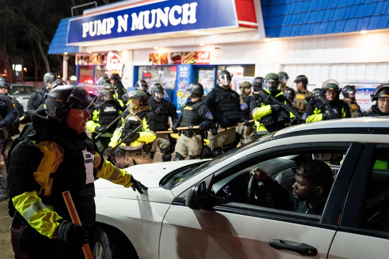 A motorist is ordered to move his vehicle as police expand their defensive perimeter after issuing orders to disperse during a protest against the police shooting of Daunte Wright, late Monday, April 12, 2021, in Brooklyn Center, Minn.