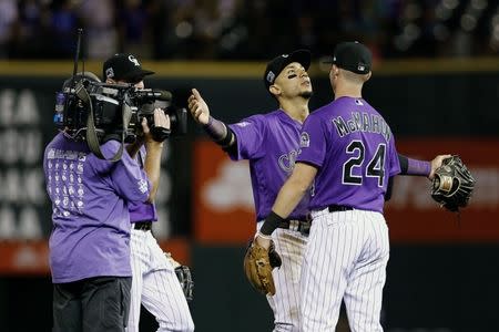 Aug 10, 2018; Denver, CO, USA; Colorado Rockies right fielder Carlos Gonzalez (5) celebrates with third baseman Ryan McMahon (24) after defeating the Los Angeles Dodgers at Coors Field. Mandatory Credit: Isaiah J. Downing-USA TODAY Sports