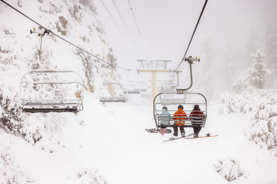 In this photo provided by Big Bear Mountain Resort, people are surrounded by snow while riding a lift in Big Bear Lake, Calif., Tuesday Feb. 6, 2024. The resort has received three feet of new snow over the last week, with some of the heaviest periods of snowfall occurring last night. (Big Bear Mountain Resort via AP)