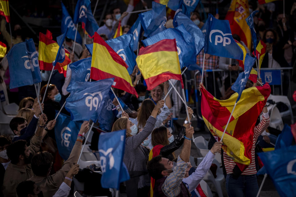 Supporters of conservative Madrid president Isabel Diaz Ayuso wave flags outside the popular party headquarters in Madrid, Spain, Tuesday, May 4, 2021. Over 5 million Madrid residents have voted for a new regional assembly in an election that tests the depths of resistance to lockdown measures and the divide between left and right-wing parties. (AP Photo/Bernat Armangue)