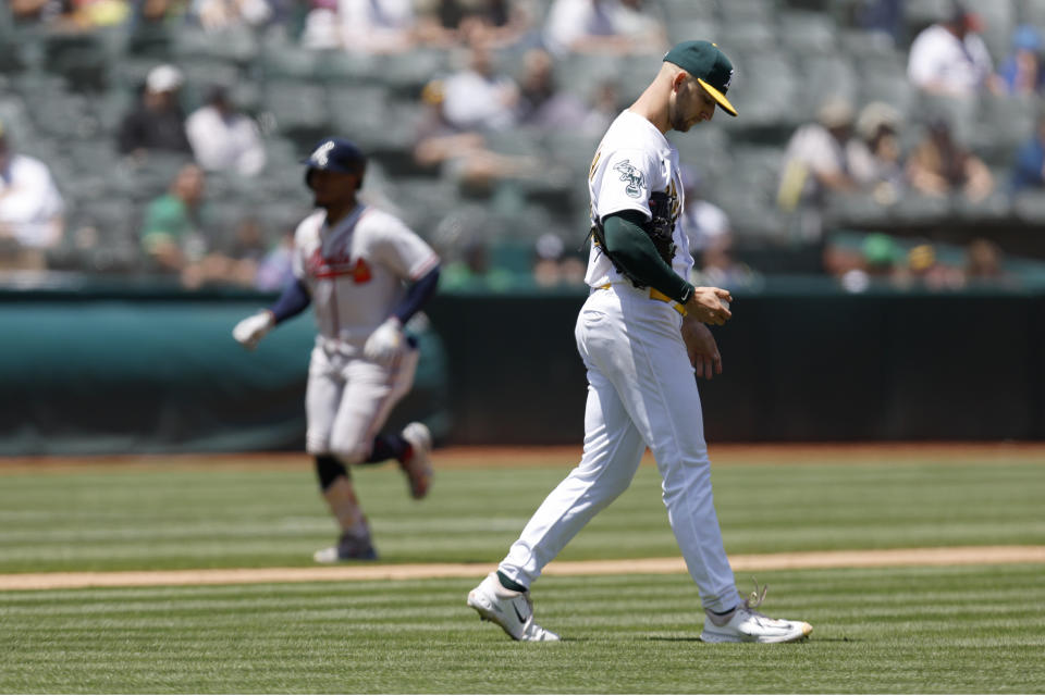 Oakland Athletics starting pitcher James Kaprielian, right, walks back to the mound as Atlanta Braves' Ozzie Albies, left, rounds the bases after hitting a two-run home run during the fifth inning of a baseball game in Oakland, Calif., Thursday, May 31, 2023. (AP Photo/Jed Jacobsohn)