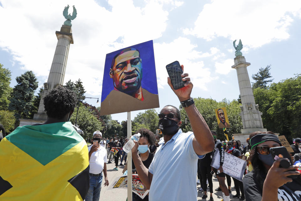 A protester uses his cell phone camera to record during a Caribbean-led Black Lives Matter rally at Brooklyn's Grand Army Plaza, Sunday, June 14, 2020, in New York. (AP Photo/Kathy Willens)