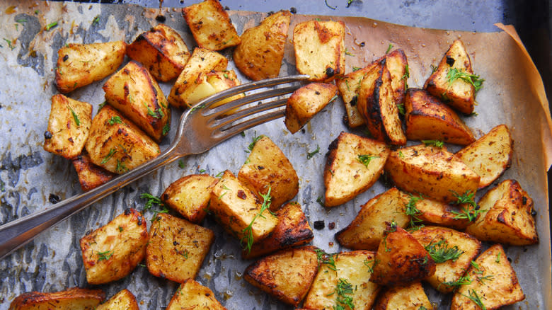 Roasted potatoes on parchment paper with fork 