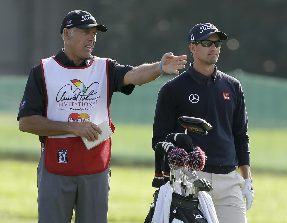 Caddie Steve Williams, left, gestures as he talks to Adam Scott, of Australia, on the 16th fairway during the first round of the Arnold Palmer Invitational golf tournament at Bay Hill Thursday, March 20, 2014, in Orlando, Fla. (AP Photo/Chris O'Meara)