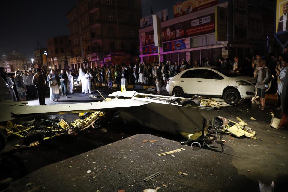 People gather around the wreckage of a drone aircraft which Houthi rebels claimed to have shot down, in Sanaa, Yemen, Monday, May 23, 2022. (AP Photo/Hani Mohammed)