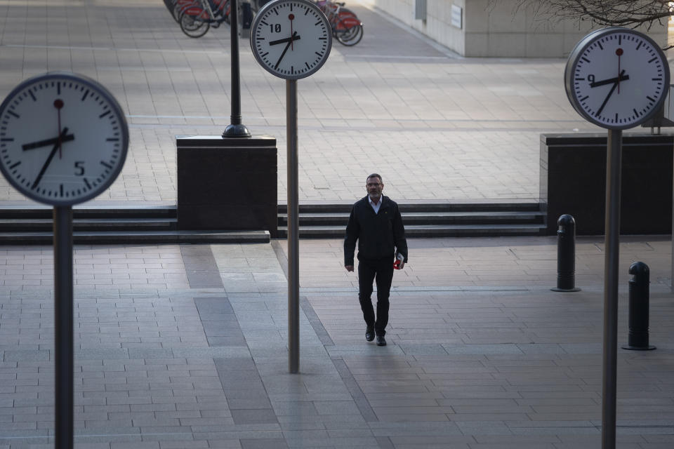 A man walks in Canary Wharf, London during rush hour, after Prime Minister Boris Johnson has put the UK in lockdown to help curb the spread of the coronavirus.