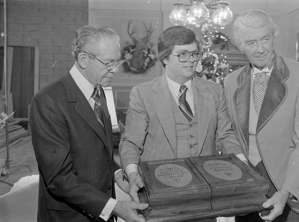 Jimmy Stewart, far right and N. Eldon Tanner, of the Church of Jesus Christ of Latter-day Saints, left along with an unidentified church employee from the Family History Center, center present Jimmy Stewart with his Family History records in March of 1980 while he was filming Mr. Krugers Christmas. Deseret News Archive | Deseret News