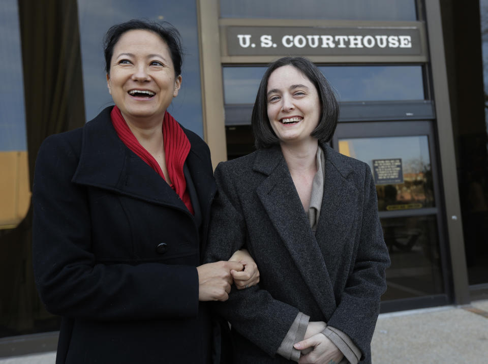 Cleopatra De Leon, left, and partner, Nicole Dimetman, right, arrive at the U.S. Federal Courthouse, Wednesday, Feb. 12, 2014, in San Antonio, where a federal judge is expected to hear arguments in a lawsuit challenging Texas' ban on same-sex marriage. (AP Photo/Eric Gay)