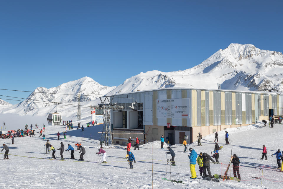 La Plagne, France - January 24, 2019: Station of the overhead cabin cable car Roche de Mio in ski resort La Plagne in France, part of Paradiski skiing area. People skiing, relaxing and enjoying views at the altitude of 2.700 m