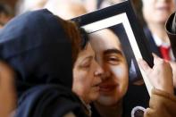 A relative of Elvin Bugra Arslan, one of the victims of Sunday's suicide bomb attack, holds his picture during a funeral ceremony in Ankara, Turkey March 15, 2016. REUTERS/Umit Bektas