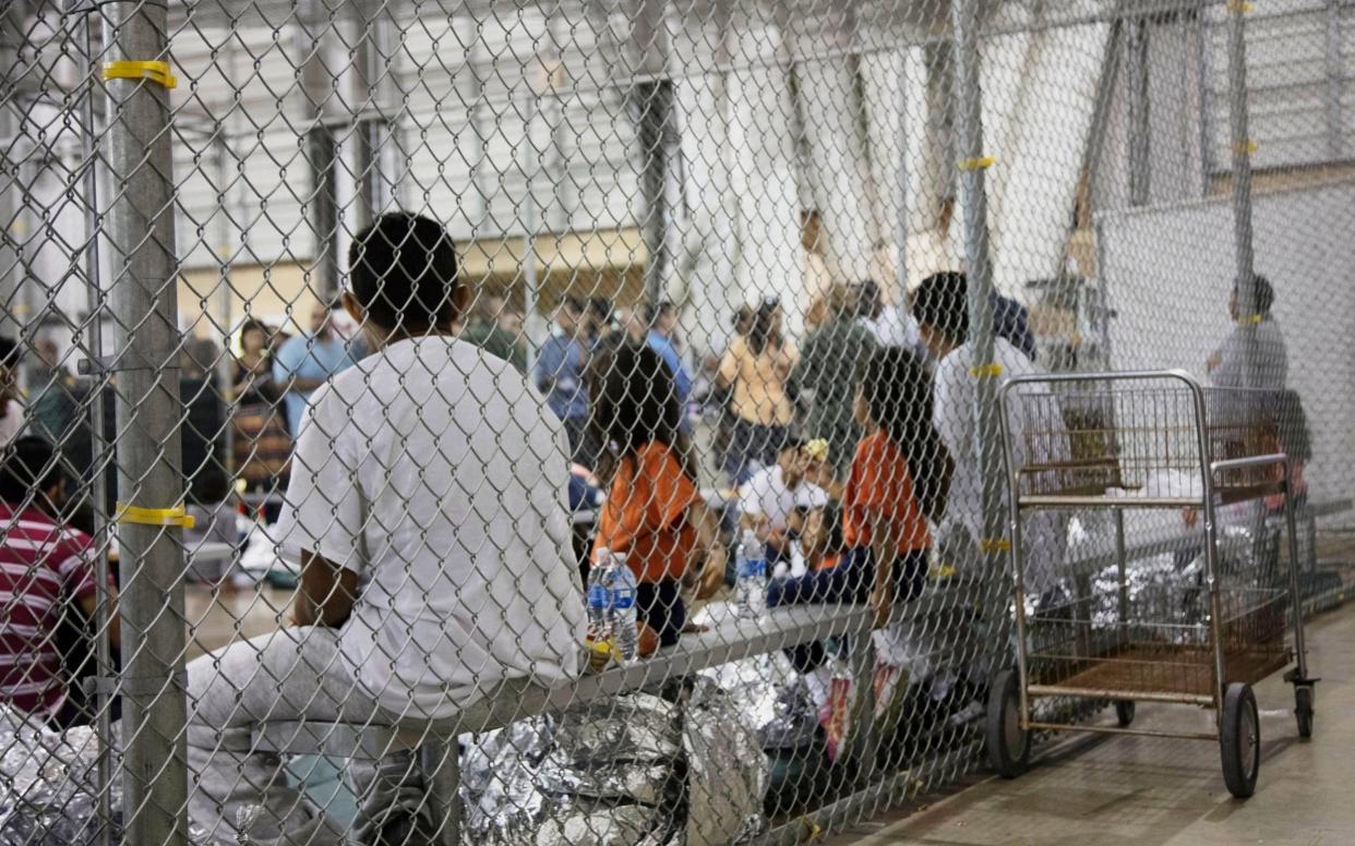 People who've been taken into custody related to cases of illegal entry into the United States, sit in one of the cages at a facility in McAllen, Texas - U.S. Customs and Border Protection's Rio Grande Valley Sector