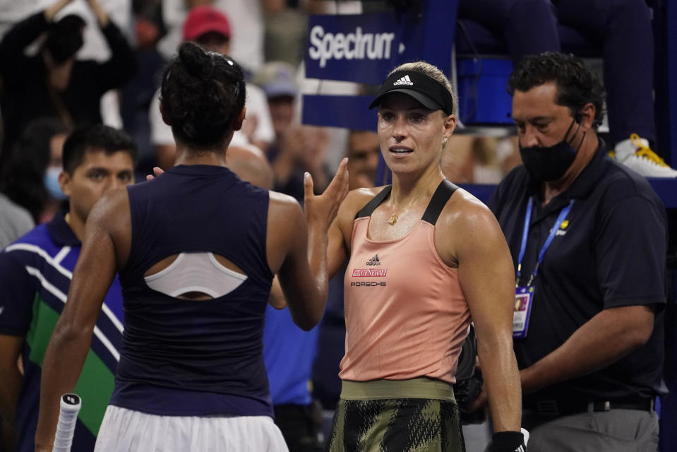 Leylah Fernandez, of Canada, left, shakes hands with Angelique Kerber, of Germany, at the end of their match, won by Fernandez, during the fourth round of the US Open tennis championships, Sunday, Sept. 5, 2021, in New York. (AP Photo/John Minchillo)