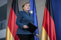 German Chancellor Angela Merkel arrives for a press conference about coronavirus, in Berlin, Sunday, March 22, 2020. German authorities have issued a ban on more than two people meeting outside of their homes, which they believe will be easier to follow than locking people in their homes. The vast majority of people recover from the new coronavirus. According to the World Health Organization, most people recover in about two to six weeks, depending on the severity of the illness. (Michael Kappeler/Pool photo via AP)