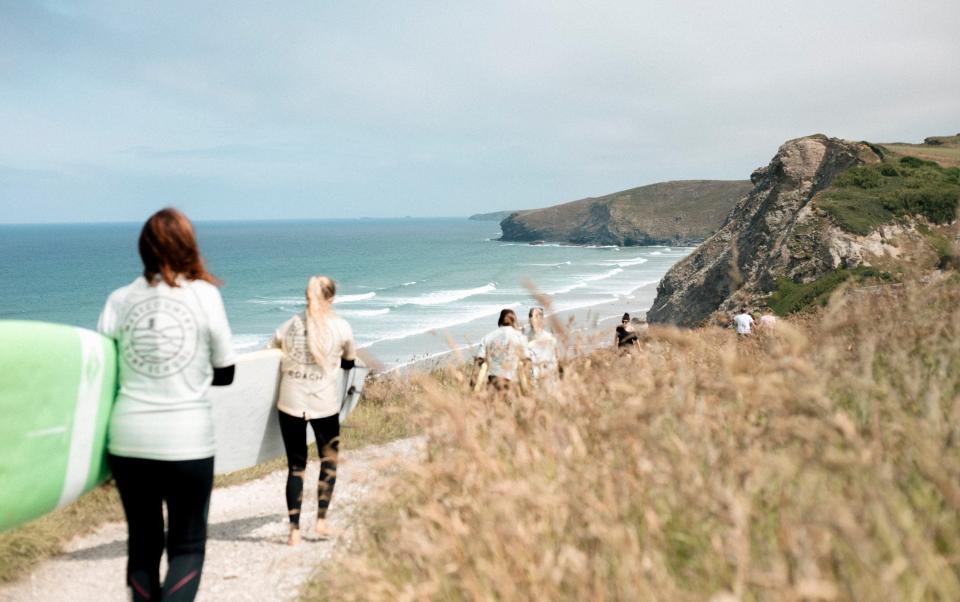 Surfers approaching a Cornish beach with their boards