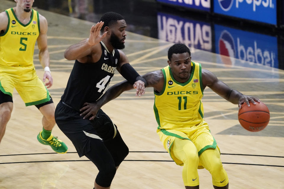 Oregon guard Amauri Hardy, right, drives past Colorado forward Jeriah Horne in the first half of an NCAA college basketball game Thursday, Jan. 7, 2021, in Boulder, Colo. (AP Photo/David Zalubowski)