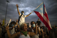 People march along Las Americas Highway to protest the LUMA Energy company in San Juan, Puerto Rico, Friday, Oct. 15, 2021. Ever since LUMA began providing service over the summer, hundreds of thousands of Puerto Ricans have had to deal with widespread blackouts for extended periods of time, voltage fluctuations and bad customer service along with an increase in pricing. (AP Photo/Carlos Giusti)