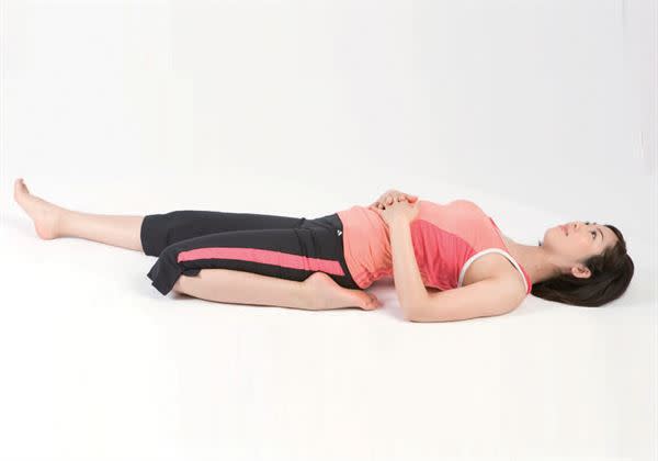 仰躺，往臀部旁彎曲做逆伸展的左腳，讓腳底靠著臀部，上半身向後慢慢倒下，頭部貼地。接著換邊，重複上述動作。（圖片／蘋果屋出版提供）