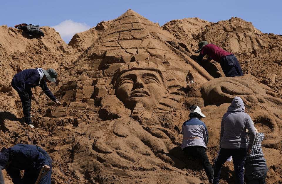 Artists work on a sand sculpture depicting a pharaoh and a pyramid, as part of Good Friday celebrations in Arenales de Cochiraya, on the outskirts of Oruro, Bolivia, Friday, April 7, 2023. Artists gathered for the annual Holy Week event in the highland region, building sand sculptures based on Bible stories. (AP Photo/Juan Karita)