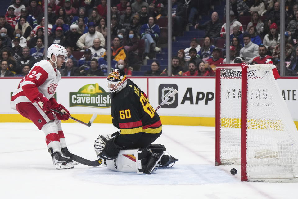 Detroit Red Wings' Pius Suter (24) scores against Vancouver Canucks goalie Collin Delia (60) during the third period of an NHL hockey game in Vancouver, British Columbia, Monday, Feb. 13, 2023. (Darryl Dyck/The Canadian Press via AP)