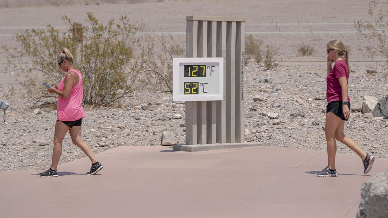 Visitors walk past the thermometer at the Furnace Creek Visitor Center in Death Valley, California, U.S., on Thursday, June 17, 2021.(Kyle Grillot/Bloomberg via Getty Images)