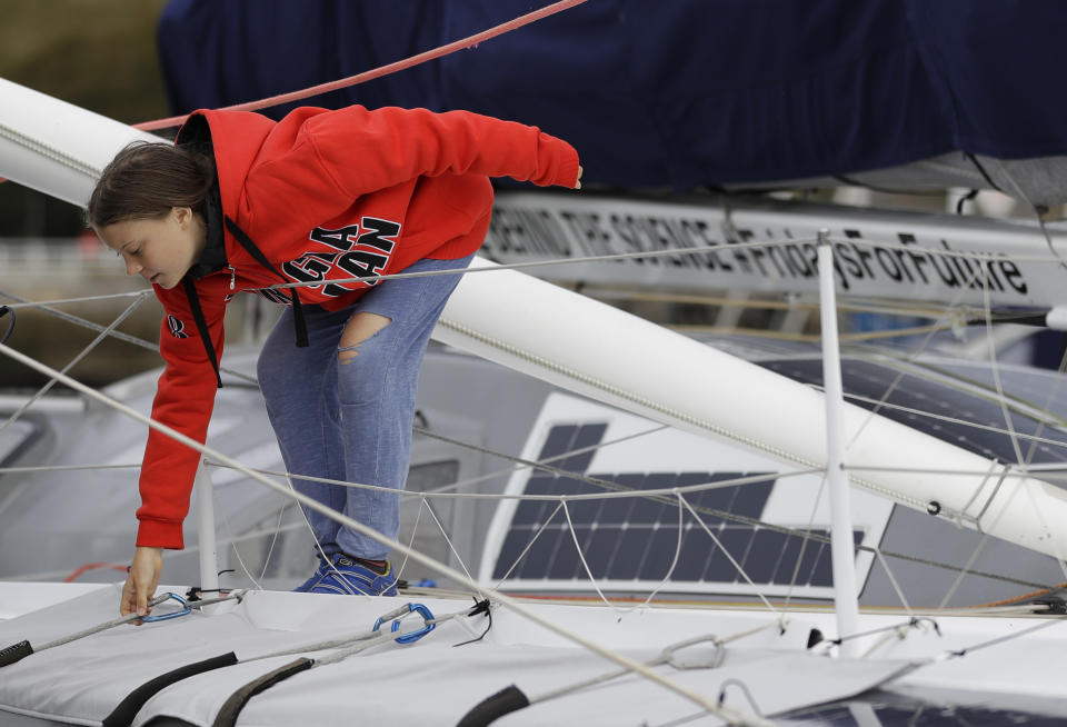 Greta Thunberg climbs onto the boat Malizia as it is moored in Plymouth, England Tuesday, Aug. 13, 2019. Greta Thunberg, the 16-year-old climate change activist who has inspired student protests around the world, is heading to the United States this week - in a sailboat. (AP Photo/Kirsty Wigglesworth)
