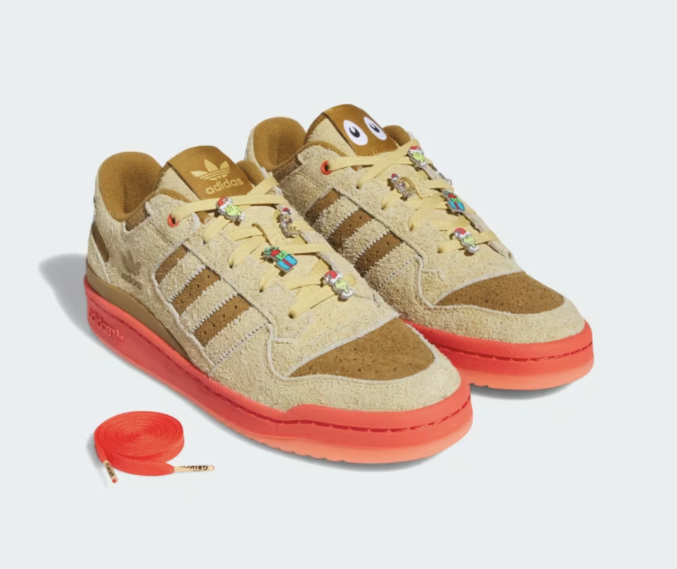 brown suede sneakers with red sole, grinch pins and red laces