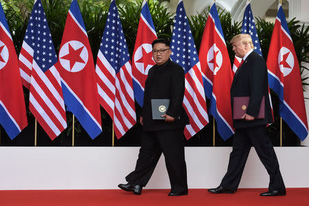 U.S. President Donald Trump and North Korea's leader Kim Jong Un walk during their summit at the Capella Hotel on Sentosa island in Singapore June 12, 2018. Anthony Wallace/Pool via Reuters