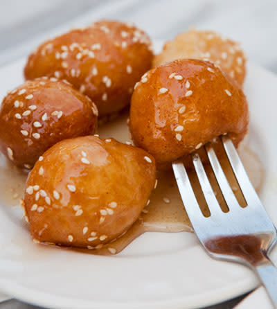 <b>Loukoumades (Greece)</b> <br> Loukoumades are traditionally served at festivals and carnivals. Eaten while still warm, they are made by deep-frying sweet dough balls and then drizzling with honey syrup. The loukoumades are then sprinkled with sugar, cinnamon, walnuts or sesame seeds.