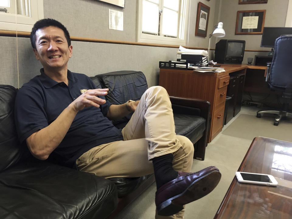 In this Friday, March 10, 2017 photo, Hawaii Attorney General Douglas Chin sits in his office in Honolulu. Hawaii was the first state to file a lawsuit challenging President Donald Trump's revised travel ban. For Chin, the son of Chinese immigrants, fighting the travel ban is personal. (AP Photo/Jennifer Sinco Kelleher)