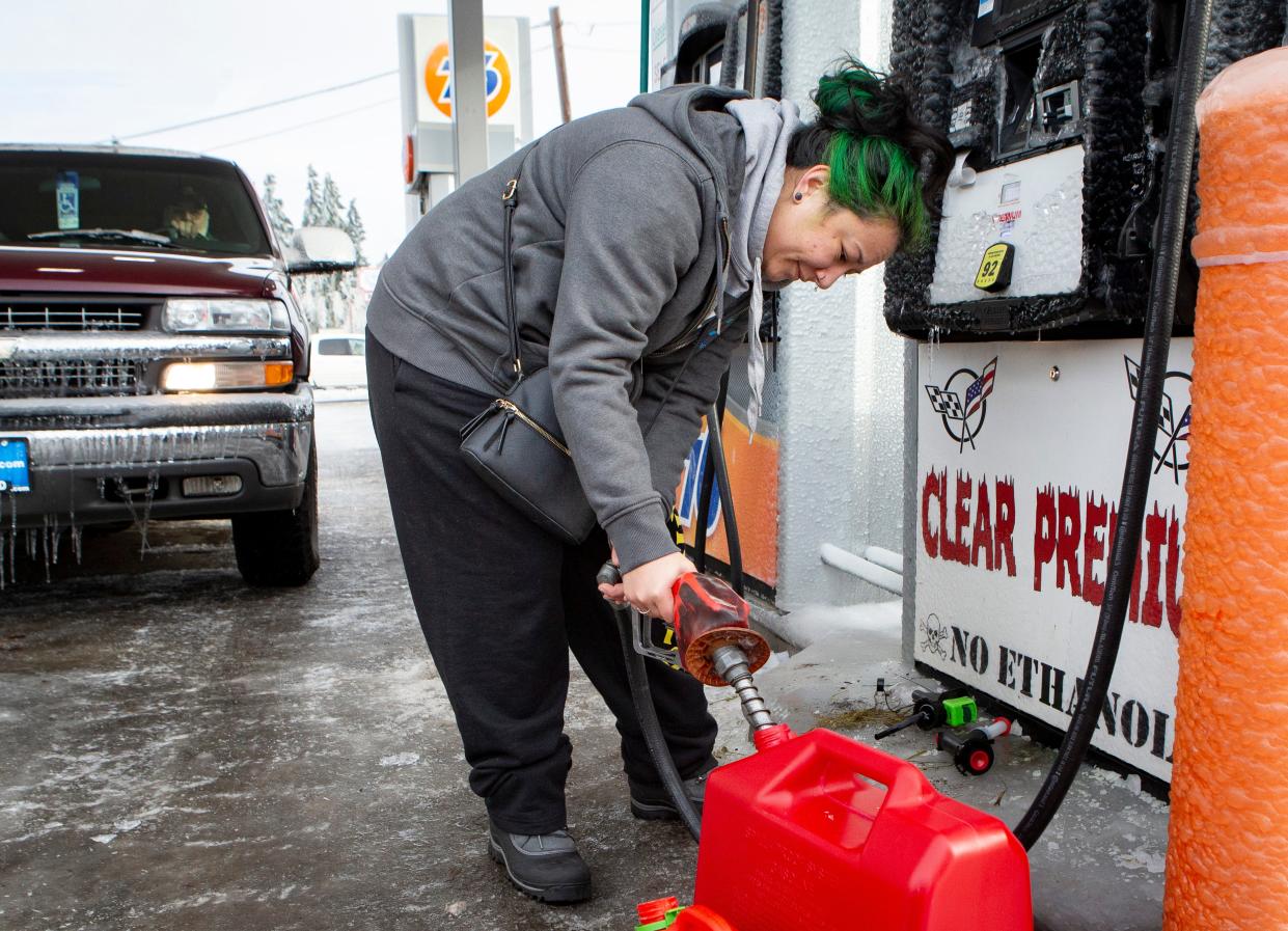 Julia Rhodes refills a gas can for her generator during a winter storm Tuesday, Jan. 16, 2024, in Springfield, Ore.