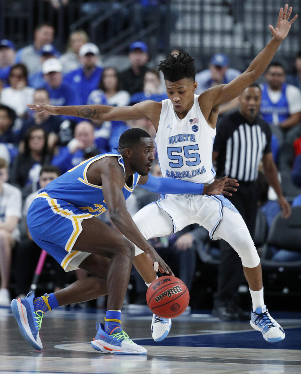 UCLA's Prince Ali (23) drives into North Carolina's Christian Keeling during the first half of an NCAA college basketball game Saturday, Dec. 21, 2019, in Las Vegas. (AP Photo/John Locher)