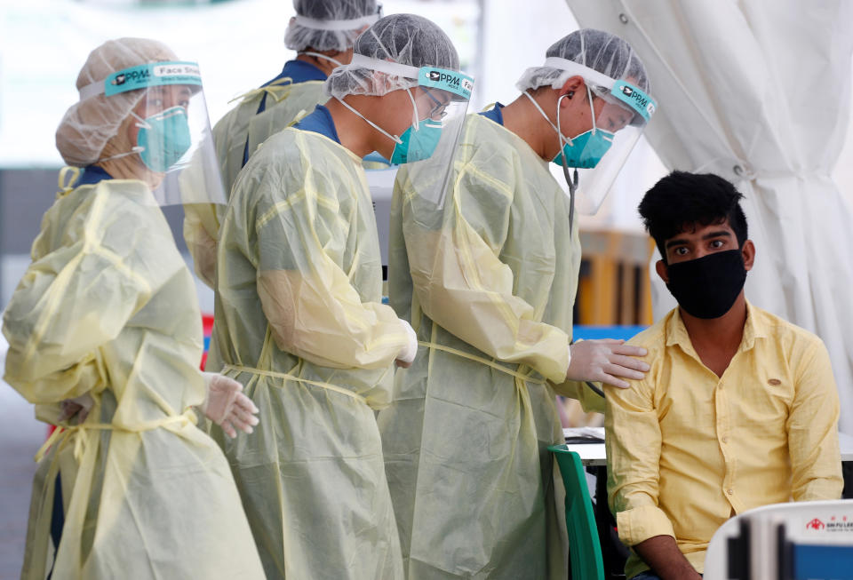 Medical workers prepare to perform a nose swab on a migrant worker at a dormitory, amid the coronavirus disease (COVID-19) outbreak in Singapore May 15, 2020.  REUTERS/Edgar Su