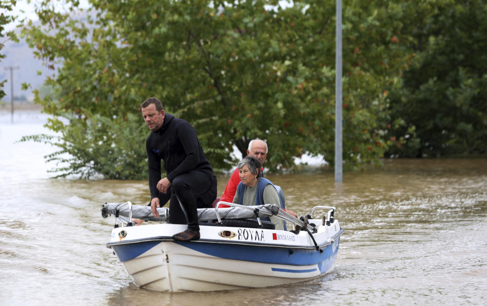 Local residents use a small boat during an evacuee operation from the village of Farkadona, Thessaly region, central Greece, Thursday, Sept. 7, 2023. Greece's fire department says more than 800 people have been rescued over the past two days from floodwaters, after severe rainstorms turned streets into raging torrents, hurling cars into the sea and washing away roads. (AP Photo/Vaggelis Kousioras)