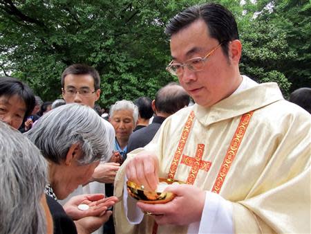 Rev. Thaddeus Ma Daqin gives the holy communion to a woman at Sheshan Cathedral, Shanghai in this April 30, 2012 picture provided to Reuters by ucanews.com on October 11, 2013. REUTERS/ucanews.com/Handout via Reuters