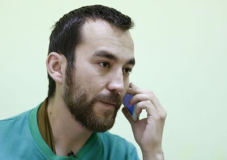 A man, according to Ukraine's state security service (SBU) is named Yevgeny Yerofeyev and is one of two Russian servicemen recently detained by Ukrainian forces, tries to call his relatives on a mobile phone at a hospital in Kiev, Ukraine, May 28, 2015. REUTERS/Valentyn Ogirenko