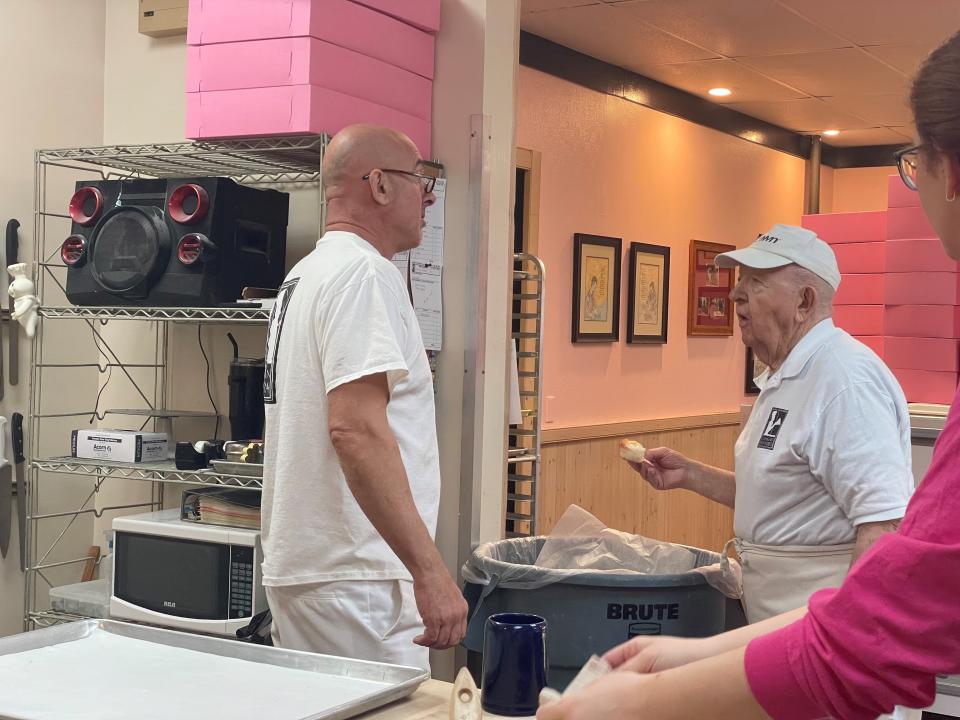 Tony Weibl, left, talks to Andrew's Pastries owner Andrew Swartz while munching on one of the cupcakes he made. Weible, 92, owned Tony’s Pastry Shop in Galion, and now makes periodic visits to the Marion bakery where he mixes it up behind and in front of the counter.