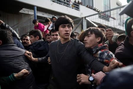 Refugees and migrants, most of them Afghans, block the entrance of the refugee camp at the disused Hellenikon airport as police officers arrive to disperse them, in Athens, Greece, February 6, 2017. REUTERS/Alkis Konstantinidis