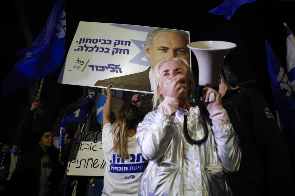 Supporters of Israeli Prime Minister Benjamin Netanyahu gather outside his residence in Jerusalem, Thursday, Nov. 21, 2019. Israel's attorney general charged Netanyahu with fraud, breach of trust and accepting bribes in three different scandals. It is the first time a sitting Israeli prime minister has been charged with a crime. (AP Photo/Ariel Schalit)