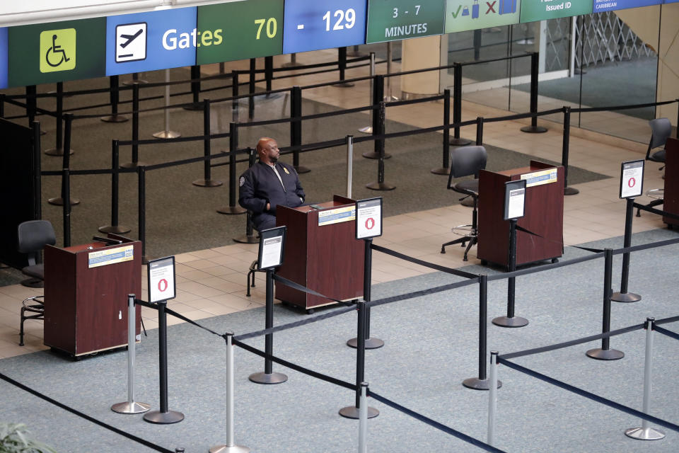 Lines that would normally be full of people waiting to go their boarding gates are now empty as a lone TSA agent on duty for security reasons sits at Orlando International Airport that is closed due to the anticipated arrival of Hurricane Dorian on the East Coast Tuesday, Sept. 3, 2019, in Orlando, Fla. (AP Photo/John Raoux)