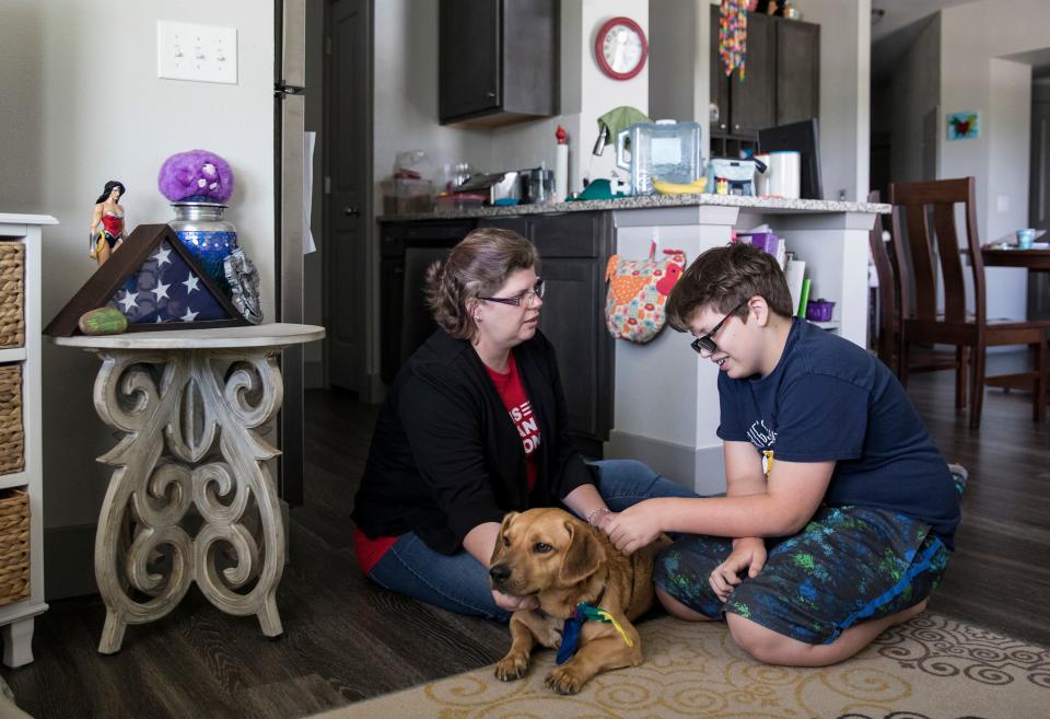 Rhonda Hart and her son Tyler, 12, pet their dog Mario at their apartment in Santa Fe, Texas, on Sunday, May 26, 2019. Rhonda Hart’s daughter, Kimberly Vaughn was one of the students killed in the May 2018 shooting at Santa Fe High School where a 17-year-old gunman killed eight students and two teachers and injured 13 others.