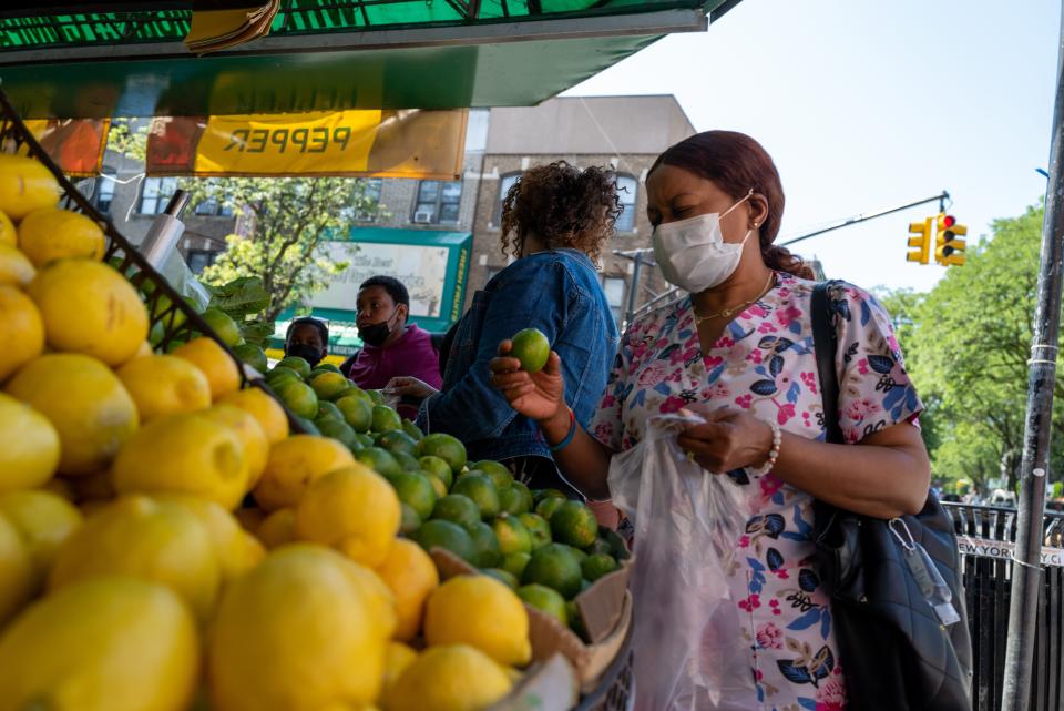 People shop for food along a busy street in Brooklyn on June 15, 2022 in New York City.