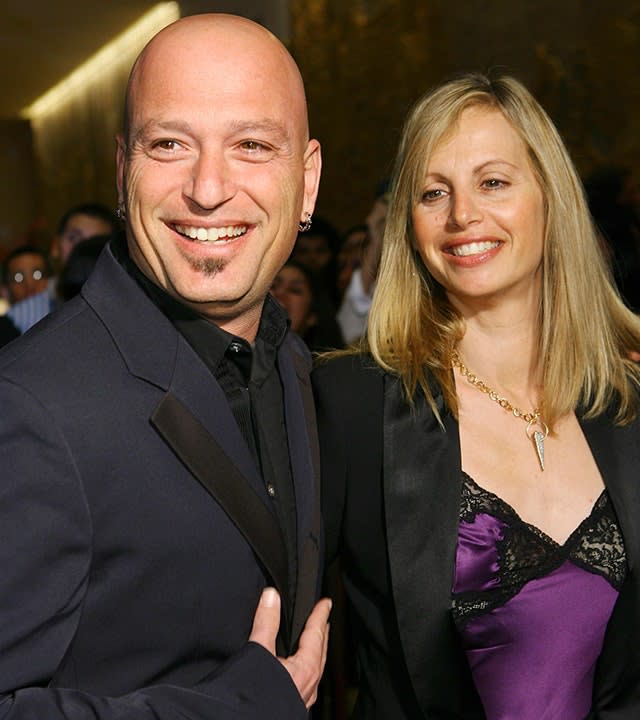 Howie Mandel in a black suit with wife Terry in a purple and black lace dress