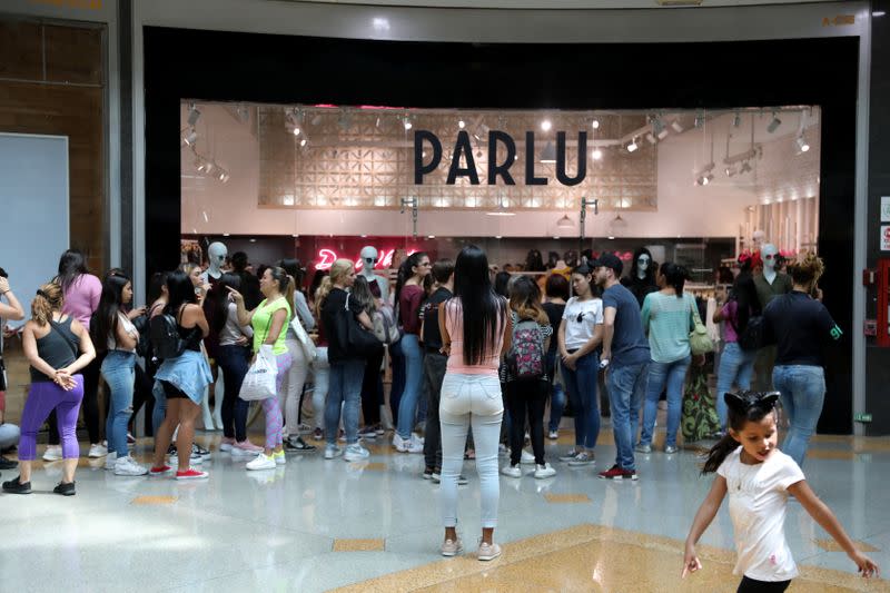 A woman stands in front of a store at a mall during the Black Friday sales in Caracas