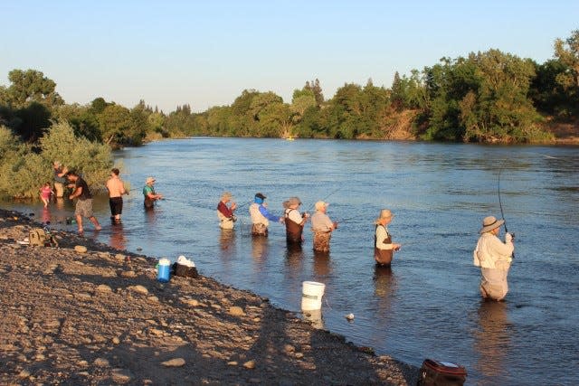 Anglers fish the clear waters of the American River, a tributary of the Sacramento, for shad on a beautiful spring evening.